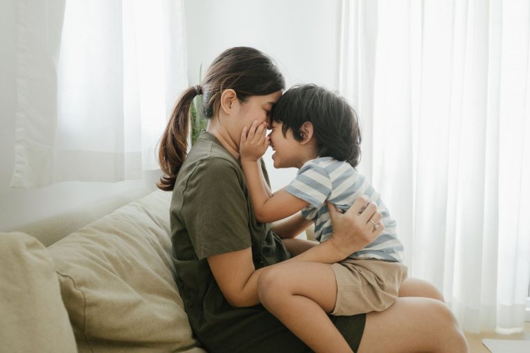 Mom with child on laps on the sofa embracing each other in soft parenting move